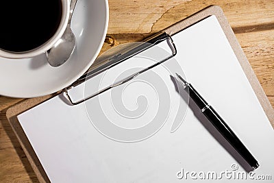 Blank white notebook, pen and cup of coffee