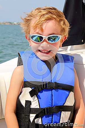 Blond 6yr old child with life jacket & sun glasses