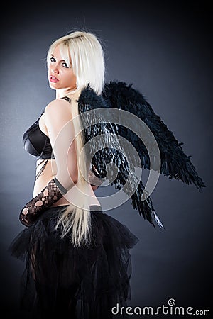 Blond female angel with black wings on a black background