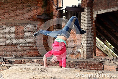 Blond girl dancing break dance in the old brickworks