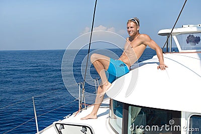 Blond handsome young man on sailing boat.