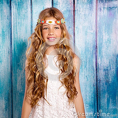Blond happy hippie children girl smiling on blue wood