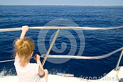 Blond little girl rear view sailing in boat