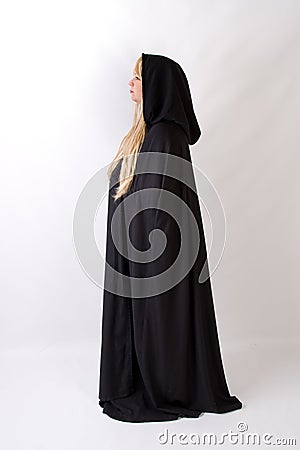 Blond woman in black hooded cloak side view