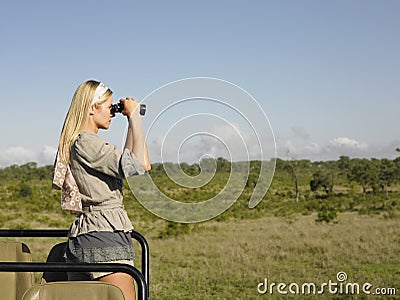 Blond Woman Looking Through Binoculars In Jeep