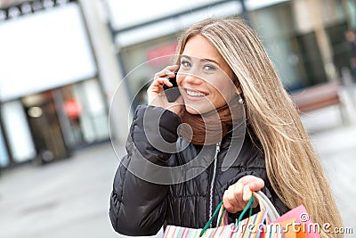 Blond woman shopping and phoning