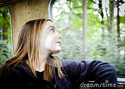 Blonde girl looking out of a train window