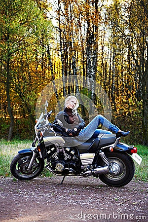 The blonde lies on the big motorcycle