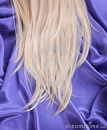 Blonde straight hair on blue silk fabric