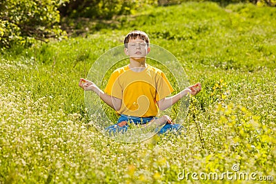 Blonde teen boy in a lotus position meditating, meditation on na
