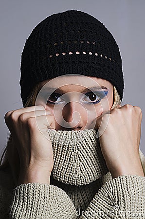 Blonde woman covering her face with turtleneck vertical