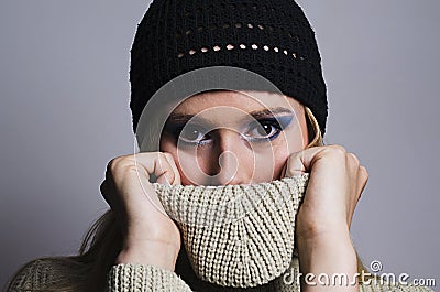 Blonde woman covering her face with turtleneck