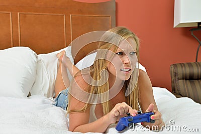 Blonde woman with video game controller - bedroom