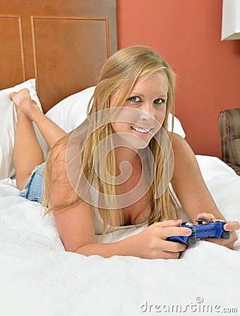 Blonde woman with video game controller - bedroom