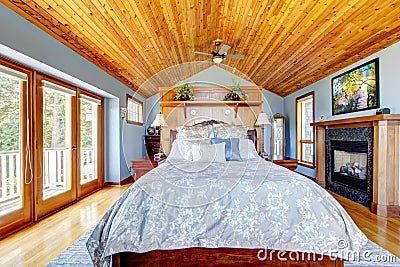 Blue bedroom with wood ceiling and fireplace