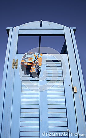 Blue dress cabin at the beach with a swimming suit hanging out
