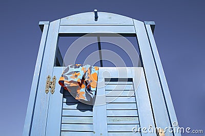 Blue dress cabin at the beach with a swimming suit hanging out