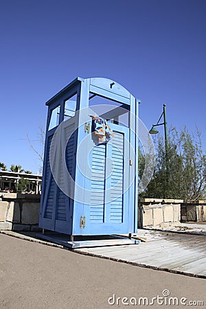 Blue dress cabin at the beach with a swimming suit hanging out