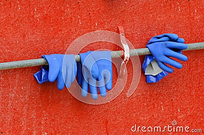 Blue gloves against red wall