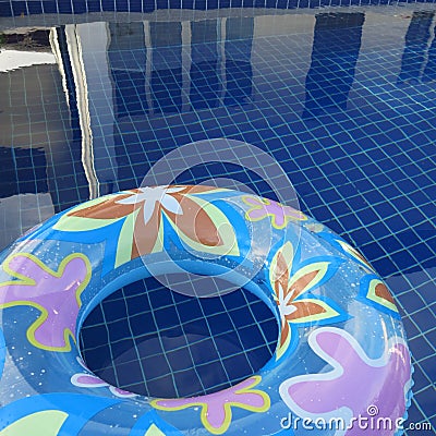 Blue inflatable round tube with flower design on the swimming pool