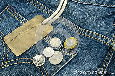 Blue jean with blank price tag and coins on background