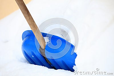 Blue snow shovel standing up in deep snow