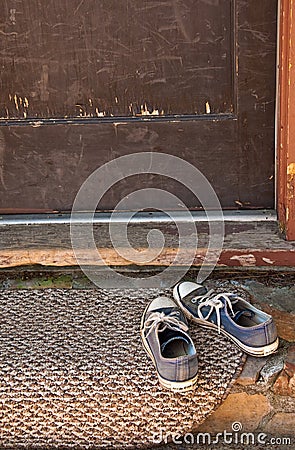 Blue tennis shoes on doormat