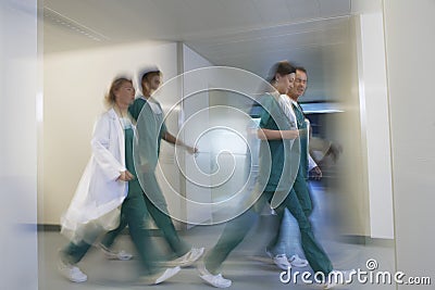 Blurred Physicians Rushing Through Hospital Corridor