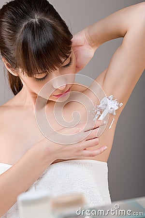 Body care: Woman shaving armpit with razor