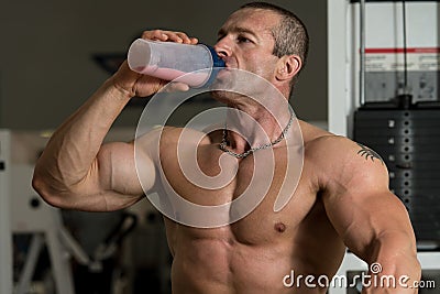 Bodybuilder Drinking From A Bottle Of Water