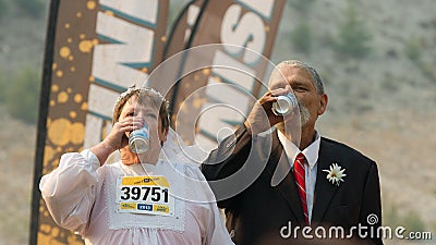 BOISE, IDAHO/USA - AUGUST: Couple in their wedding outfits drinking some beer at the The Dirty Dash in Boise, Idaho on August , 20