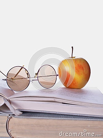 Book and apple on the wooden table