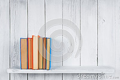Books on a wooden shelf.