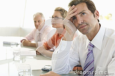 Bored Businessman Looking Away At Conference Table