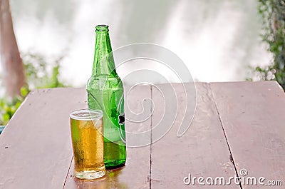 Bottle and glass with beer on wood table