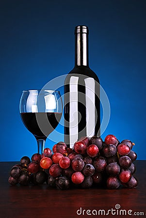 Bottle and glass of red wine with grapes