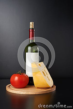 Bottle of red vine with cheese and tomato