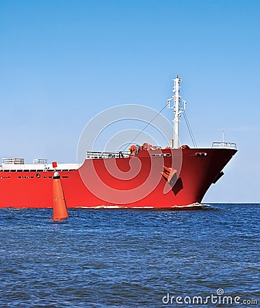 Bow of the red ship in the ocean and a red buoy.