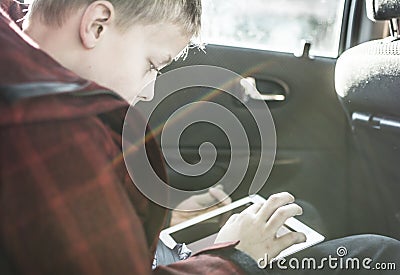 Boy in car playing on tablet pc