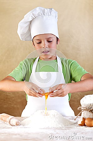 Boy with chef hat preparing the dough