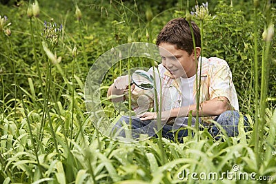 Boy Examining Plants With A Magnifying Glass