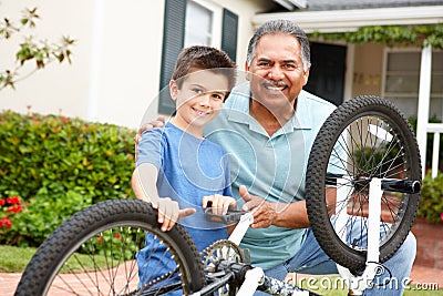 Boy and grandfather fixing bike