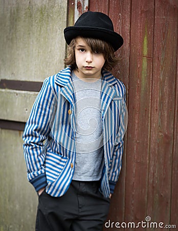 Boy with Hat Leaning Against the Wall