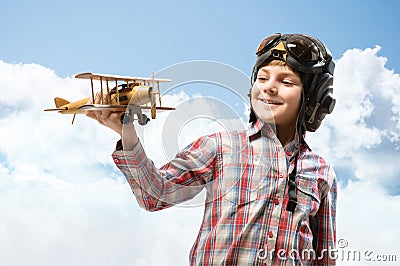 Boy in helmet pilot playing with a toy airplane