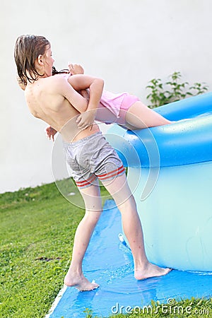 Boy helping a girl get out from a pool