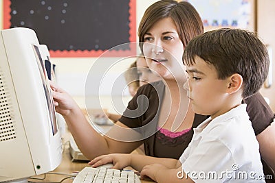 A boy and his teacher working on a computer