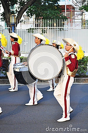 Boy hits drum in marching band