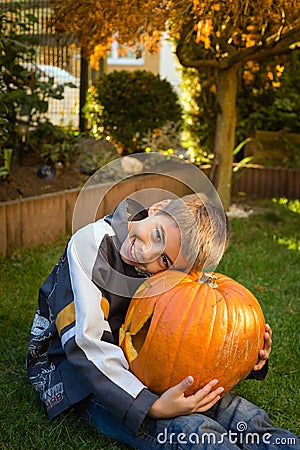 Boy holding jack-o-lantern from big pumpkin