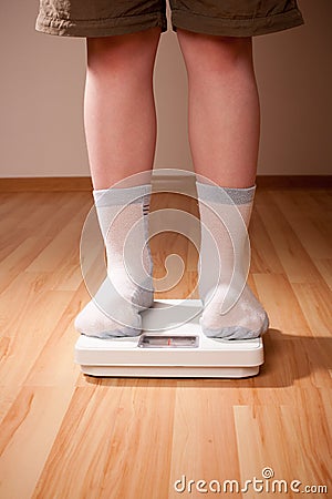 Boy measures weight on floor scales