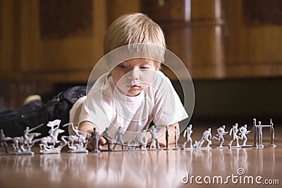 Boy Playing With Toy Soldiers On Floor